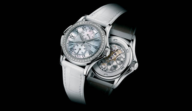 <strong>PATEK　PHILIPPE｜パテック フィリップ</strong>　カラトラバ トラベルタイム4934。2タイムゾーンを同時に表示できるトラベルタイムに、文字盤にマザー・オブ・パール、ベゼルにダイヤ、ケースにゴールド素材を採用したラグジュアリーなレディスタイプ。シースルーバックからパテック自社製の手巻きムーブメントが見られる。