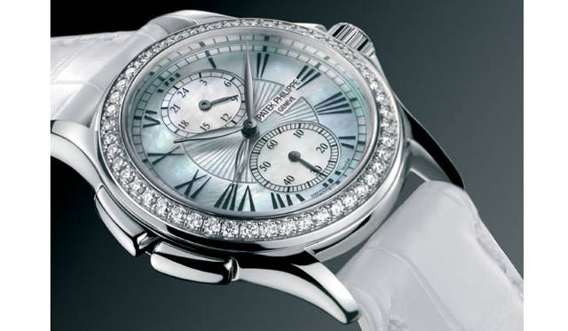 <strong>PATEK　PHILIPPE｜パテック フィリップ</strong>　カラトラバ トラベルタイム4934。中央の2本の時針は、ゴールドのリーフ型時針で旅先の現地時間（ローカルタイム）、ブラックゴールドのスケルトン針で本国時間（マザータイム）を表示可能。12時位置の24時間サブダイヤルはマザータイムを表示し続けるため旅先から本国に電話をかけるときなど相手の時間帯を考慮することが可能。2つの時間帯を表示する必要がないときは時針を重ね合わせておけばいい。