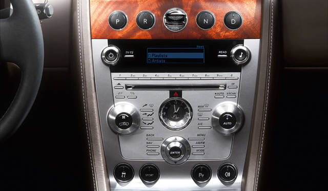 <br>伝統的なクラフトマンシップと最新の素材が出会うDB9のインテリア。センタークラスターの中央、ガラスのカバーで覆われる丸いボタンがスタータースイッチだ。