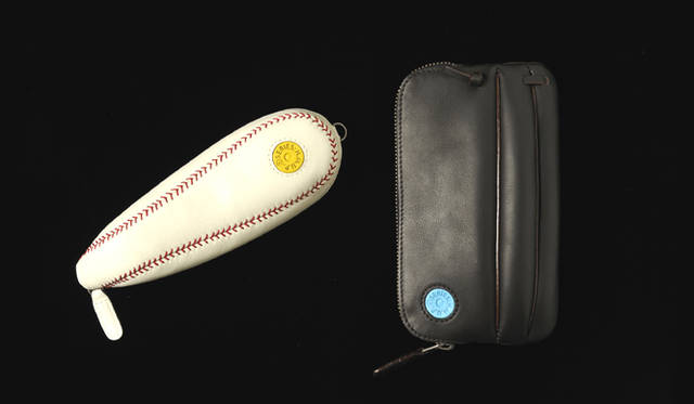 「HIKARU MATSUMURA THE UNIQUE-BAG」 フェア中に展開するペンケース。左：実際のボールと同じ108の縫い目数にこだわったペンケース。9975円、右：ペンやDSなどいろいろなものを入れられるケース。1万3650円