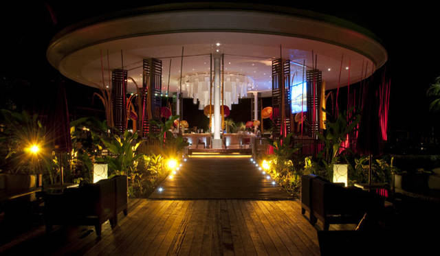 夜のメインバー。夏の香気に満たされたオープンエアの空間をほの灯りが彩る。