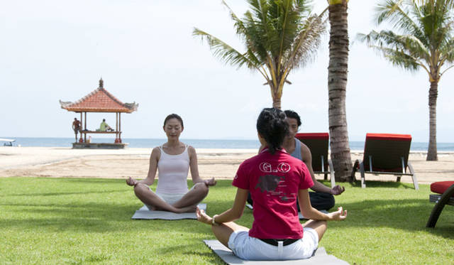 ビーチを望む芝生の上でのヨガのレッスン風景。ほかにもマリンアクティビティなど、その種類は豊富だ。