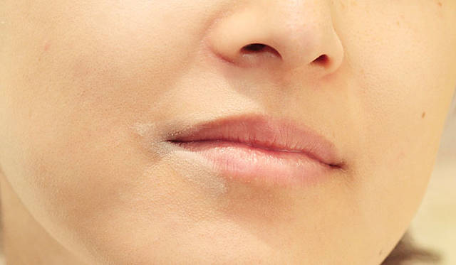 口角をアップさせるため、下側をメインに色をのせ、なじませる