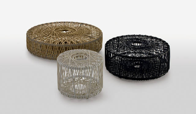 <b>REEL</b> designed by Atelier Oï（2008）<br>糸巻きのように、フレームに幾何学的にストリングを巻きつけた立体感のあるデザインの円形のオットマン。ストリングはココナッツとマニラ麻からできた自然素材のロープと2色のポリエチレンファイバーから選ぶことができる