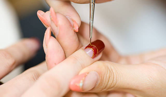 ゴールドのラメでラインを引く。逆フレンチの爪にはラインを2本