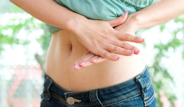 左わき腹から丹田に向かって、左の手のひらで圧をかけながらグググッと押し進める。ちから加減は、右手を重ね、おなかの内側3cmくらいを押し流す意識で。