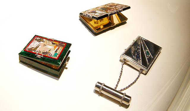 <em>Van Cleef & Arpels｜ヴァン クリーフ＆アーペル</em>　日本の海岸を描いたもの（左：1925年）など、美しいバニティケースの数々。中：「中世風バニティケース」1925年、右：青い列車の「ル トラン ブルー」1931年。