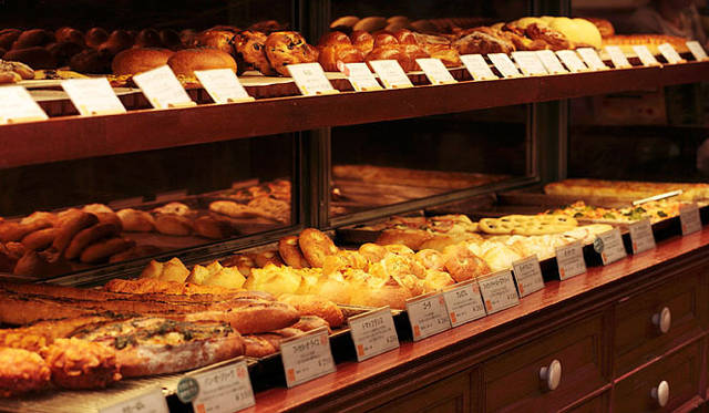 ネモ ベーカリー＆カフェ｜ずらりと並んだパンは、常時80～85種類と豊富。素材がおいしい季節になると登場する旬のメニューも多い。「ただいま焼きたて!!」のステッカーを見ながらあれこれ選びたい