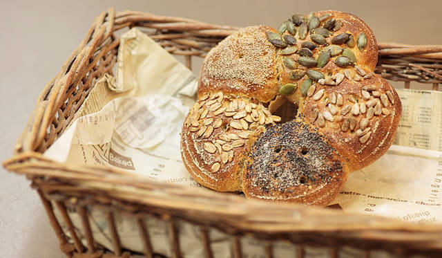 ショーマッカー｜ライ麦30％、国産小麦70％の「パーティークランツ」は、ひまわりの種、かぼちゃの種、白いケシの実、ライ麦の押し麦、黒いいケシの実が付けられた、見た目も華やかで楽しいパン。焼き上がり予定時間 10:00　1個 380円