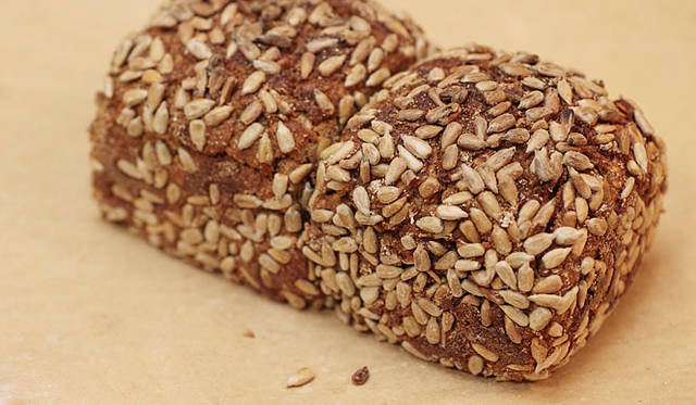 ショーマッカー｜ライ麦100％の「ゾネンブルーメ」。まわりにびっしりと付けられた、ひまわりの種の香ばしさと、程よい酸味が特長。冷え性、老化防止によいとされる、鉄分、カルシウム、ビタミンが豊富だ。焼き上がり予定時間 9:00　1個 1000円／ハーフ500円