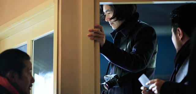 <strong>LOUIS VUITTON｜ルイ・ヴィトン</strong><br />次の撮影はファイヤーキングカフェ。窓ごしにモデルを狙うが、ウィンドーのスノーフレークディスプレイを前にしばし思案中。