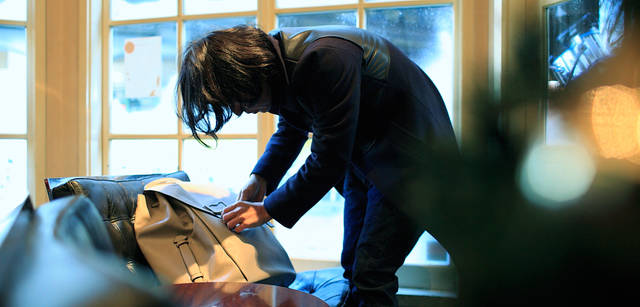 <strong>LOUIS VUITTON｜ルイ・ヴィトン</strong><br />撮影位置を決めると同時に、スタイリングを。「タイガ・ライン」リュック「サック・ア・ド」の詰め物を調節したり、ブランケットを着けてみたり、とこなれた雰囲気に仕上げていく。リュック「サック・ア・ド」55万1250円（ルイ・ヴィトン／ルイ・ヴィトン カスタマーサービスセンター　Tel. 03-3478-2100）