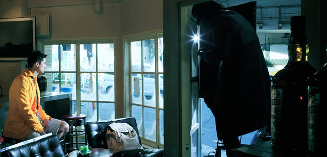 <strong>LOUIS VUITTON｜ルイ・ヴィトン</strong><br />窓越しに撮影する祐真さんのようす。