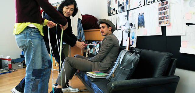 <strong>LOUIS VUITTON｜ルイ・ヴィトン</strong><br />撮影途中で、アトリエにあったメジャーを「これ使っていい？」と、スタイリングに取り入れる。モデル｜スーツケース「ミトカ」46万5150円、ジャケット18万4800円、Tシャツ4万7250円、トラウザーズ9万7650円、ハット7万4550円（すべて参考価格）、シューズ5万7750円（すべてルイ・ヴィトン／ルイ・ヴィトン カスタマーサービスセンター　Tel. 03-3478-2100）