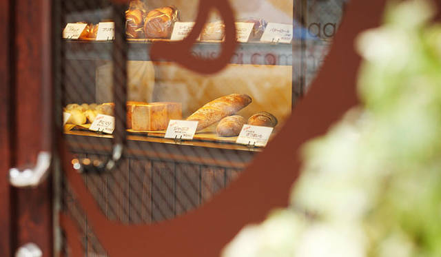 パサージュ ア ニヴォ｜ウィンドウに描かれたユーモラスな表情のキャラクター「バゲットくん」。垣間見えるパンは常時50種類ほど