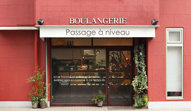パサージュ ア ニヴォ｜ひと際目を引くレンガ色の外観。店名はフランス語で「踏切」を意味する。ウィンドウからは厨房でスタッフがきびきびと働く姿が垣間見える