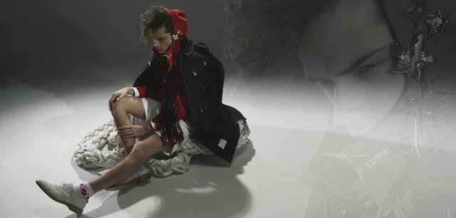 AS collection｜アズ コレクション｜フォトジェニックなブローチは、胸に着けてもそれだけでアクセントになるが、パーカのフードにあしらうと顔のまわりを彩ってくれる。ここではブローチにコーラルのブレスレットをかけてポイントにした。(ジュエリー：すべてAS collection Tel. 03-5468-6835)、コート 10万1850円、ジャケット 7万1400円、シャツ 2万5200円、ショーツ 3万450円、ソックス 1万500円、シューズ 11万5500円（すべてトム ブラウン／ステディ スタディ　Tel. 03-5469-7110）