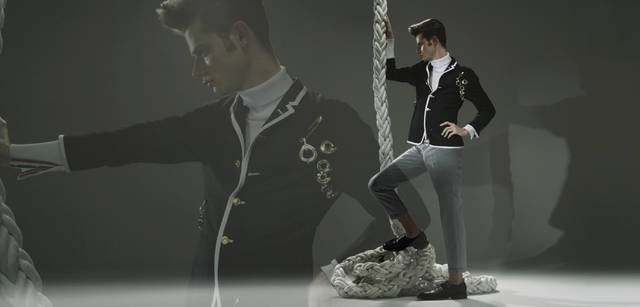 AS collection｜アズ コレクション｜袖ぐりに沿って、いくつものブローチを規則的に配したコーディネイト。構築的な美しさを誇るブローチはブローチにもペンダントヘッドにもなる。ひとつでもインパクトがあるが、重ね着けすることでデザイン性がより際立つ。(ジュエリー：すべてAS collection Tel. 03-5468-6835)、ジャケット 22万500円、パンツ 8万5050円、シューズ 11万5500円、セーター 参考商品（すべてトム ブラウン／ステディ スタディ　Tel. 03-5469-7110）