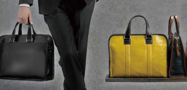 <br />左から：ディーヴォ ブリーフケース「97441｜H300×W400×D70mm」（ブラック） 6万1950円、サント ブリーフケース「97411｜H280×W380×D100mm」（イエロー、ブルーグリーン） 各5万4600円<br />シャツ 1万4700円（エディフィス）、その他 スタイリスト私物