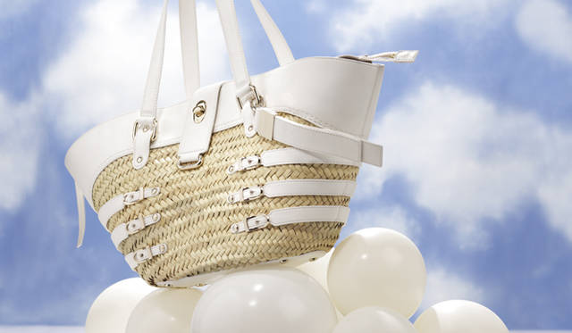 <strong>JIMMY CHOO｜ジミーチュウ</strong><br />ラフィアの軽やかさと白レザーの組み合わせはこれからの季節にぴったり。サイドのベルトづかいやゴールドの金具がポイントで効いている。ラフィアバッグ[W55×H26×D16cm]12万1800円（Jimmy Choo Tel. 03-5413-1150）