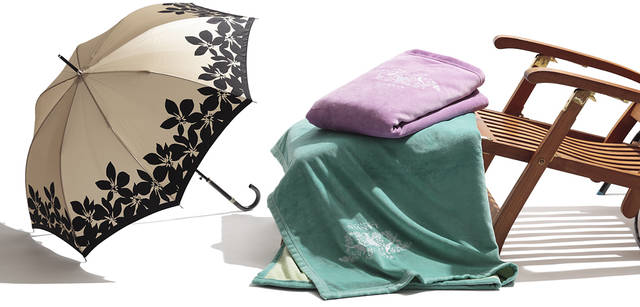 <br />洋服にもコーディネイトしやすい、単色の花柄プリント。ハンドル部分にはラインストーンが埋め込まれたりと、ディテールにも凝っている。傘8400円（ムーンバット Tel. 03-3556-6810）、リバーシブルの綿毛布は、きれいな発色が今シーズンらしい。2枚合わせ綿毛布　各7350円（ともに泰道リビング　Tel. 03-5687-2747）