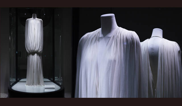 <br />白いシルクジャージー。フルレングス。厚さの異なる2種類のジャージーを使用した深いVゾーンのコンビネゾン・パンタロン型のドレス。肩から前後に垂らした薄地ジャージーは、腰部でゆったりとブラウジングされ両足内側へ分岐している。古代ギリシャ建築の円柱を彷彿させるボリューム感が彼女固有の絶妙な厳格さを醸し出している。（1978年）