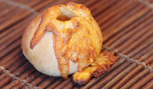 ブーランジェリー ニコラ｜フランスパンの生地に、3種類のチーズ（モッツァレラ、レッドチェダー、クリーム）を包んで焼いた「フロマージュ」。焼くと切れ目から溶けたチーズが溢れ出て、見た目もインパクト大だ。焼き上がり予定時間　昼ごろ　1個 200円