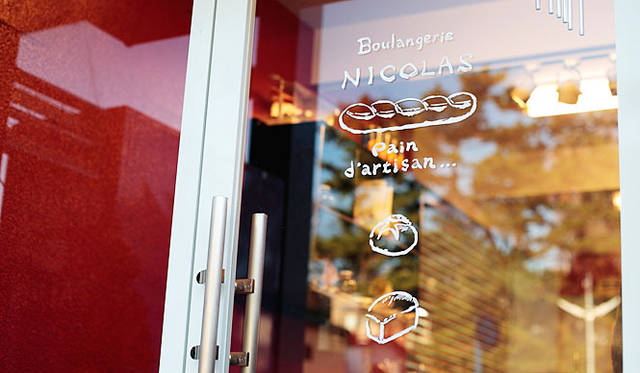 ブーランジェリー ニコラ｜ウィンドウに描かれた文字も、天板につくりつけられた時計に描かれたイラストも、杉山シェフによるもの。やさしくてあたたかい雰囲気の『ブーランジェリー ニコラ』のトレードマークだ