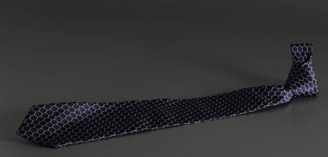 <b>dunhill｜ダンヒル</b><br />ネイビー地に、サッカーのゴールネットのモチーフ柄。大剣の裏地に「Made Exclusively For JAPAN NATIONAL FOOTBALL TEAM　By dunhill」の文字、小剣に日本代表エンブレムがプリントされている。ネクタイ 1万5750円（限定2010本）