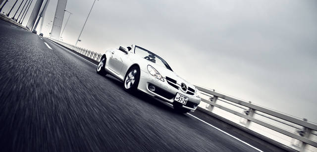 <b>Mercedes-Benz｜メルセデス・ベンツ SLK</b>　加減速はアクセルペダルに置いた足のごくわずかな力に瞬間的に反応しておこなわれ、人車一体感が強くなる。これを支えるのが新技術、ダイレクトステアリングだ。ハンドルの切れ角や切る速度から、前輪の舵角を制御する機構で、スポーティなドライビングのときは、わずかな切れ角で車両が気持ちよく向きを変えていく。
