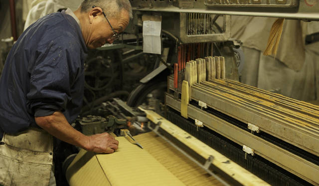 <b>MIHARAYASUHIRO｜三原康裕</b> カネタ織物の専属職人である鈴木さんは、シャトル織機の隅々まで知り尽くしたベテラン