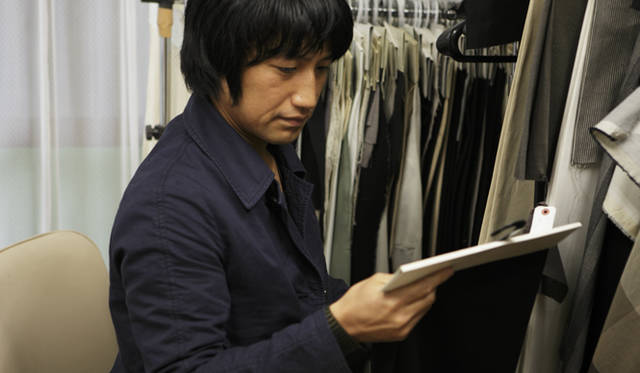 <b>MIHARAYASUHIRO｜三原康裕</b> カネタ織物のオリジナル生地をチェックする三原さんはそのクオリティを絶賛