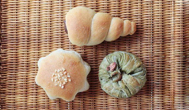 <b>erizo｜天然酵母パン エリゾー</b>　形もかわいらしい人気の菓子パン。「チョココロネ」（上：1個190円）には、ベルギーのカレボー社製チョコレートを使った自家製のチョコカスタードがたっぷり。「クリームパン」（左下：1個180円）にも自家製のカスタードを使用。「さくら」（右下：今年の分は5月末で生産終了）は、生地に桜の葉のパウダーを練り込んだオリジナル。焼き上がり予定時間　11:30～12:00