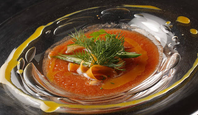 <b>ブラッスリー＆ワイン カフェ「Buzz（バズ）」</b><br>「厳選の高知トマトのガスパチョと夏野菜のリュバン、凝縮した蜜柑で深みをくわえて」<br>現地生産者との日々のやりとりを経て厳選するトマトと胡瓜、玉葱などのフレッシュな夏野菜をガスパチョに仕立て、蜜柑を凝縮させたソースで深みと力強さを添えて南国の夏を表現。また高知野菜ソムリエであるファームベジコ長崎さんより取り寄せたバジルのソースで和えた野菜のリボン状のサラダを浮かべて香りと触感を演出。