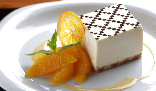 <b>GUCCI｜グッチ</b>　ひし形にデザインされたこのケーキには「ダイヤモンド パターン」が描かれたホワイトチョコレートのプレートがトッピングされ、フレッシュオレンジ、輪切りにスライスされたオレンジブルチャーレ、フレッシュミントとともにプレートを彩り、見た目にも爽やかに美しい。