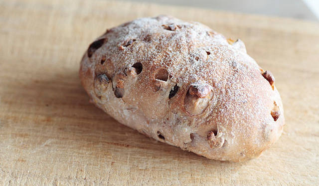 <b>AOSAN｜アオサン</b>　ぷっくりとしたかたちの天然酵母パン「アヴリーヌ（ホワイトチョコ入り）」のなかには、ホワイトチョコレートとヘーゼルナッツ、くるみ、レーズンがごろごろと入っている。チョコの入っていないタイプもあり。焼き上がり予定時間 10:00　1個330円 