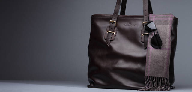 <b>Salvatore Ferragamo｜サルヴァトーレ フェラガモ</b>　上質なブラウンのカーフレザーにゴールドの金具づかいがエレガントな表情を湛える。容量大きめのトートバッグは、ビジネスシーンにもプライベートでも重宝するアイテム。内側にはキャメルカラーのファブリックが貼られ、開けたときにも上品な雰囲気。バッグ[W39×H40×D15cm] 14万7000円、マフラー3万7800円、サングラス3万9900円（サルヴァトーレ フェラガモ／フェラガモ・ジャパン）