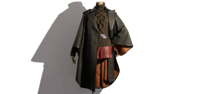 <b>Salvatore Ferragamo｜サルヴァトーレ フェラガモ</b>　エポーレットやレザートリミングがミリタリーなニュアンスを醸すポンチョ。ダブルフェイスで裏地が鮮やかなオレンジ色になっており、動くたびに見えるのが新鮮。コート 58万5900円、インナーに着たカーキのケーブル編みニット 16万8000円、ナッパのショートパンツでアクティブな印象。ショートパンツ 20万4750円（すべてサルヴァトーレ フェラガモ／フェラガモ・ジャパン）