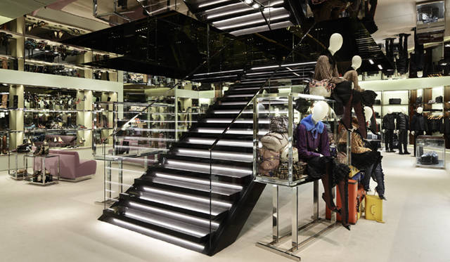 <strong>PRADA｜プラダ</strong>　1階と2階を結ぶ黒大理石の階段。吹き抜けの壁面に配されたブロンズのミラーに光が反射し、印象的な空間を作り出している。