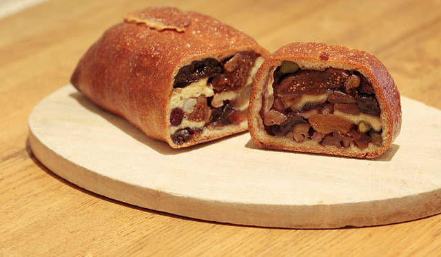 <strong>Loin montagne｜ロワンモンターニュ</strong>　卵、牛乳、バター不使用。プラムやアプリコットなど、10種類のドライフルーツやナッツをたっぷりと包み込んで焼きあげた「宝石のようなパン・オ・フリュイ」。スライスして紅茶と一緒にどうぞ。焼き上がり予定時間9:00　1本2000円　1/2 1000円　1切れ 250円