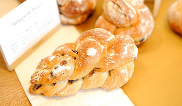 <strong>FAUCHON｜フォション</strong>　秋の新作パンコレクション「Grappe de Raisin（グラップ ド レザン）」 294円<br>ボジョレー・ヌーボー解禁を祝って発売されるパン。ワインづくりに使用するブドウをかたどり、赤ワインでマリネしたレーズンをくわえている。そのままおやつパンとして楽しめるのはもちろん、加工肉やチーズ、とくにドライソーセージに合わせるのがお薦め。