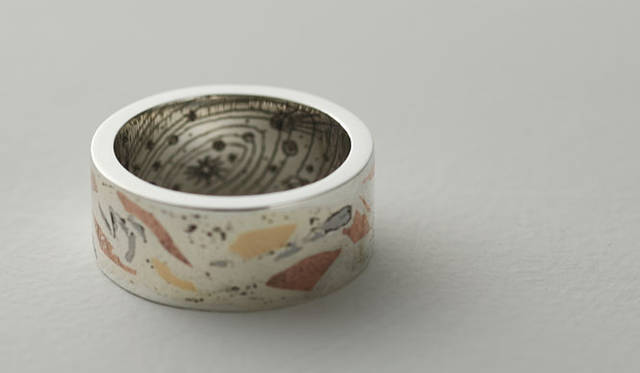 <strong>Solferino｜AVM</strong>　「かがやき」6万900円<br>シルバーのプレートの表面を溶かし、K20と銅と鉄成分の隕石をいれ込んである。宇宙のカガヤキを表現。内側には太陽系の彫柄。流れ星が飛んでいる。隕石は流れ星のカケラ。流れ星を手にもつ。