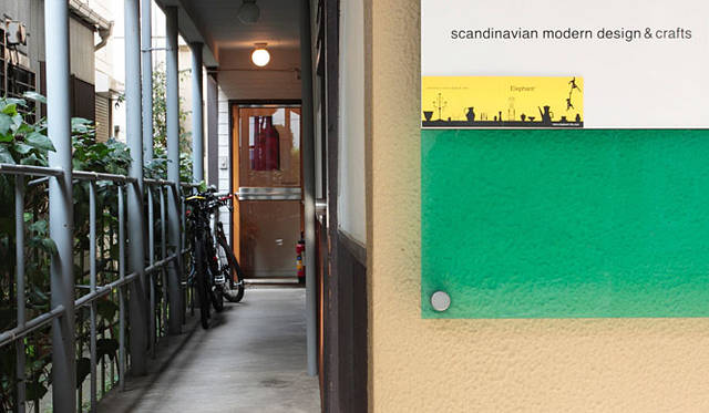 <strong>Elephant*｜エレファント</strong>　アパート手前の壁の看板が目印。廊下の突き当たりが『Elephant*』だ。