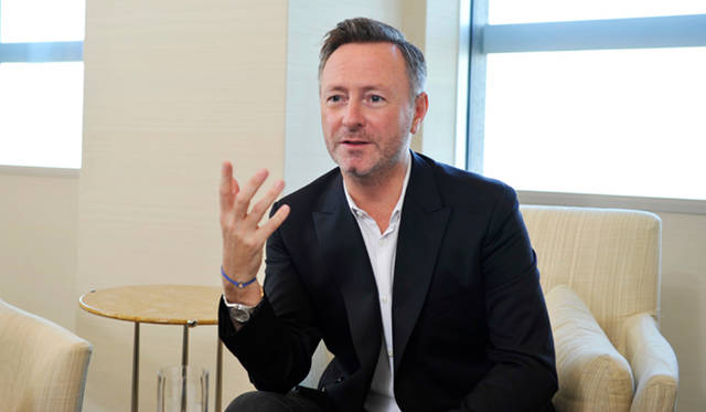 <strong>ck Calvin Klein｜ck カルバン・クライン</strong>　この日のスタイルはピークドラペルのシングルジャケットに、ホワイトシャツをラフに着ていた。ボトムはブラックデニム。ともにミニマルでシャープなラインを強調したckらしいフォルムを描くアイテムが氏の表情をきりりと引き立てる。