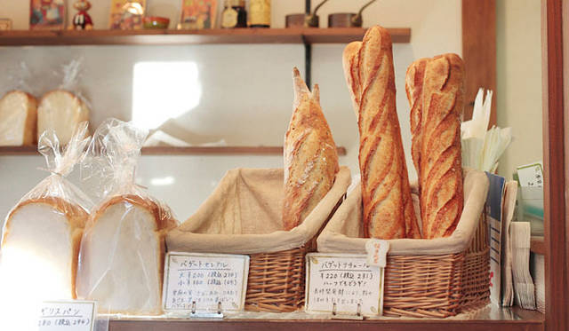 <strong>Boulangerie Copain｜ブーランジェリー コパン</strong>　向かって右のカゴ「バゲットナチュール」は、長時間発酵で粉の旨味を充分に引き出した看板商品。左の「バゲットセレアル」は、亜麻の実、きび、あわなど、雑穀入りの香ばしいバゲット。バゲットナチュールは開店時から、日に3回焼かれる。「バゲットナチュール」1本231円、ハーフ 115円。「バゲットセレアル」大210円、小105円