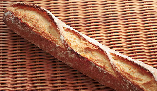 <strong>PANADERIA TIGRE｜パナデリア ティグレ</strong>　石臼挽き粉を使い、極限までイーストを減らして48時間の長時間発酵をさせて焼きあげた新製品の「バゲット48」。粉本来の旨味を引き出し、外はパリッと中はもっちりの食感。焼き上がり予定時間 11:00　1本340円、1/2 170円