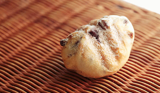 <strong>PANADERIA TIGRE｜パナデリア ティグレ</strong>　天然酵母のぶどうパンの生地に、クリームチーズとフレッシュブルーベリーを包み込んで焼いた「ブルドーム」は、三角形のユニークなかたち。焼きあがり予定時間 12:00  1個200円 