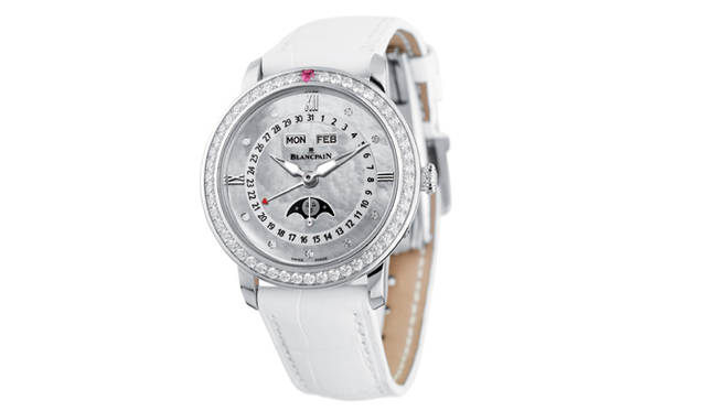 <strong>BLANCPAIN｜ブランパン</strong>　白のレザーストラップが高貴な印象。ベゼルの12時位置にあるハート型のルビーと日付針の先端を飾るハートの赤が、くっきりと優美なコントラストを生み出す。