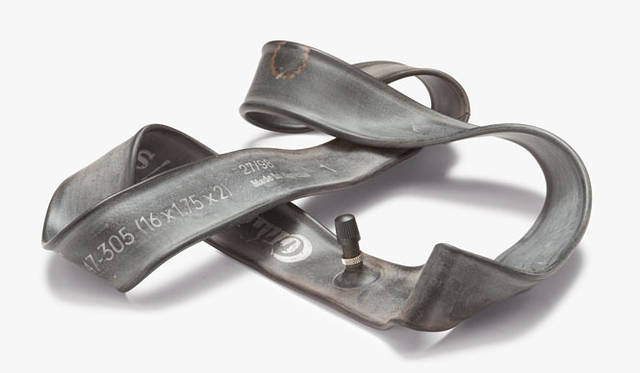 <strong>PASS THE BATON GALLERY</strong>　Recycled Bicycle Innertube / 年間使用本数 3万5000本<br>バッグのパイピング（縁取り）の役割を担う自転車タイヤのインナーチューブ。色とりどりのトラックの幌をバッグのメイン生地にして、コーポレートカラーのひとつでもあるブラックのロゴ、ストラップ、パイピング、そしてベルクロを設えることで、機能性もさることながらバッグデザインをより際立たせた。