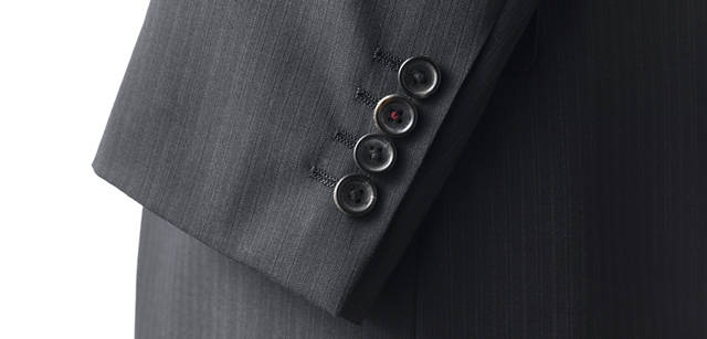 <strong>Paul Smith｜ポール・スミス</strong> 　PS ポール・スミス　ポール・スミスらしいインディビジュアリティがさりげなく表現されている、袖ボタン。第2ボタンの糸が赤でかがられている。